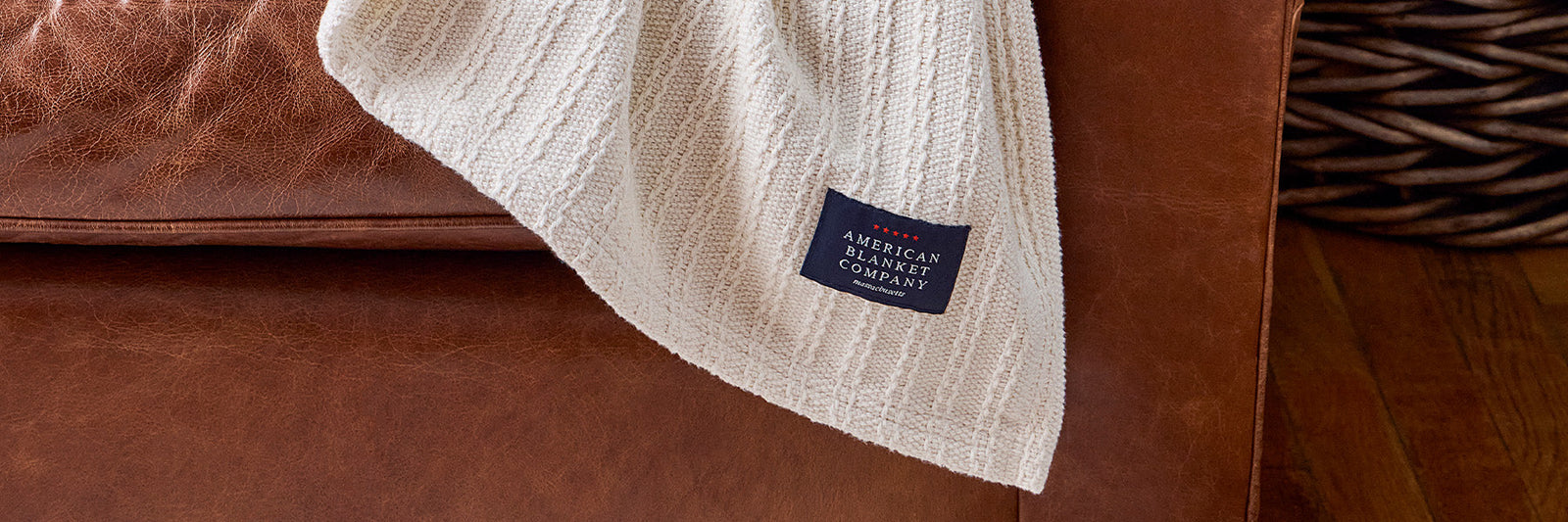 American Blanket Company - 100% Cotton Blankets - The best cotton blankets for summer sleeping - a 100% cotton blanket draped off of a leather arm chair