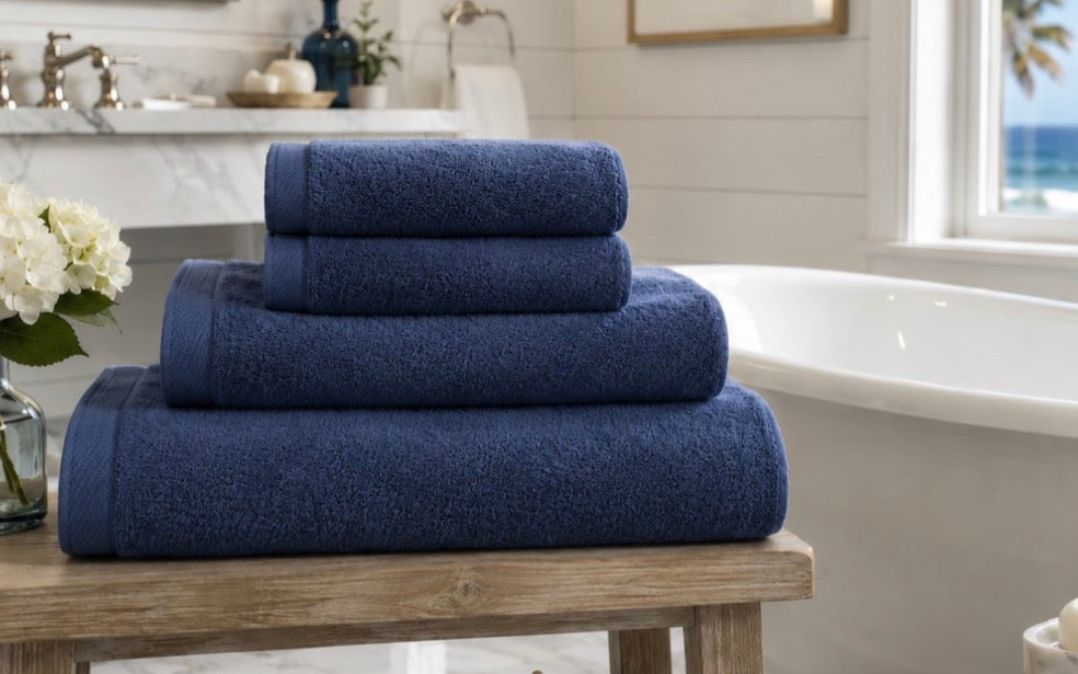 Navy Blue spa towels made in USA on bench in seaside bathroom, American Blanket Company. This towel is dual sided, smooth side for softness, looped side for absorption.