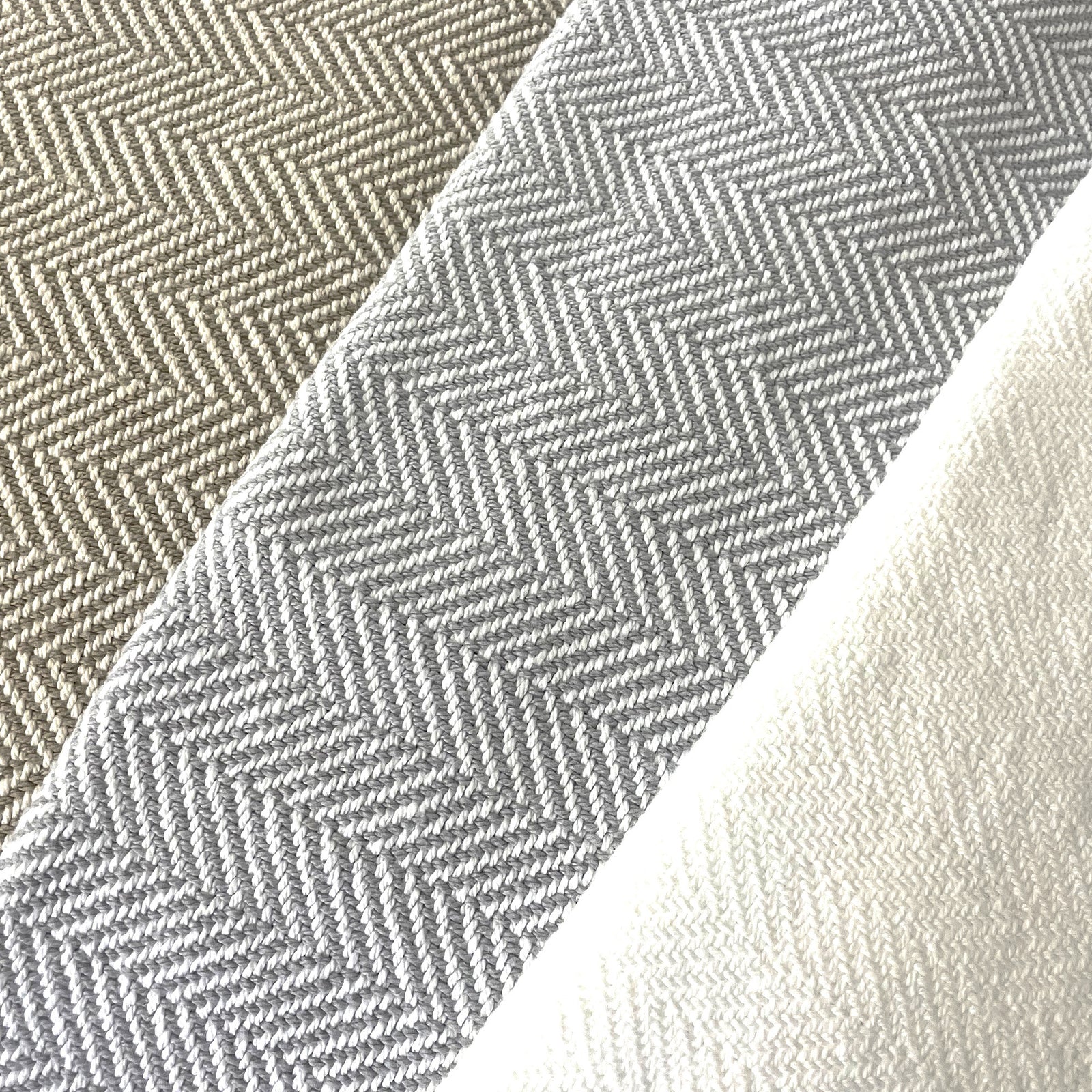 American Blanket Company - 100% Cotton Bed Blanket, Feather Weave Pattern cotton Blanket - Fan out of the various blanket colors showing white, gray and white, and khaki and white in a lovely herringbone