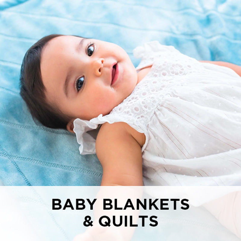 AMERICAN BLANKET COMPANY - FLEECE BABY BLANKETS - A BABY LYING ON A FLEECE LUSTER LOFT FLEECE BLANKET QUILT SMILING UP AT THE CAMERA