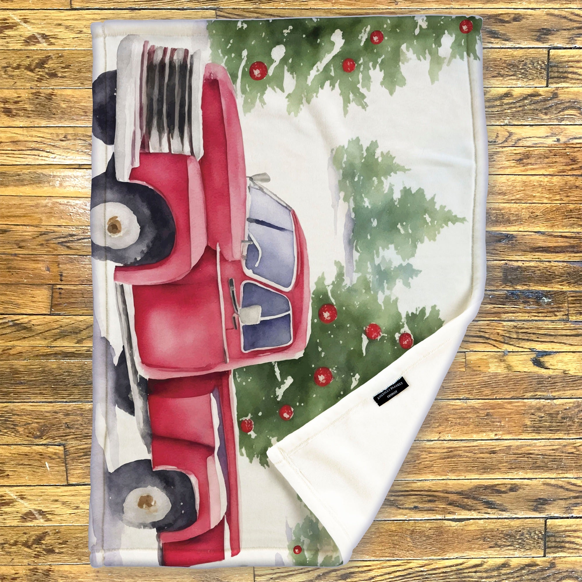 American Blanket Company - Luster Loft Fleece Blanket - Printed Holiday Throw Blanket - Fleece blanket with a red car and Christmas tree design on a wooden surface