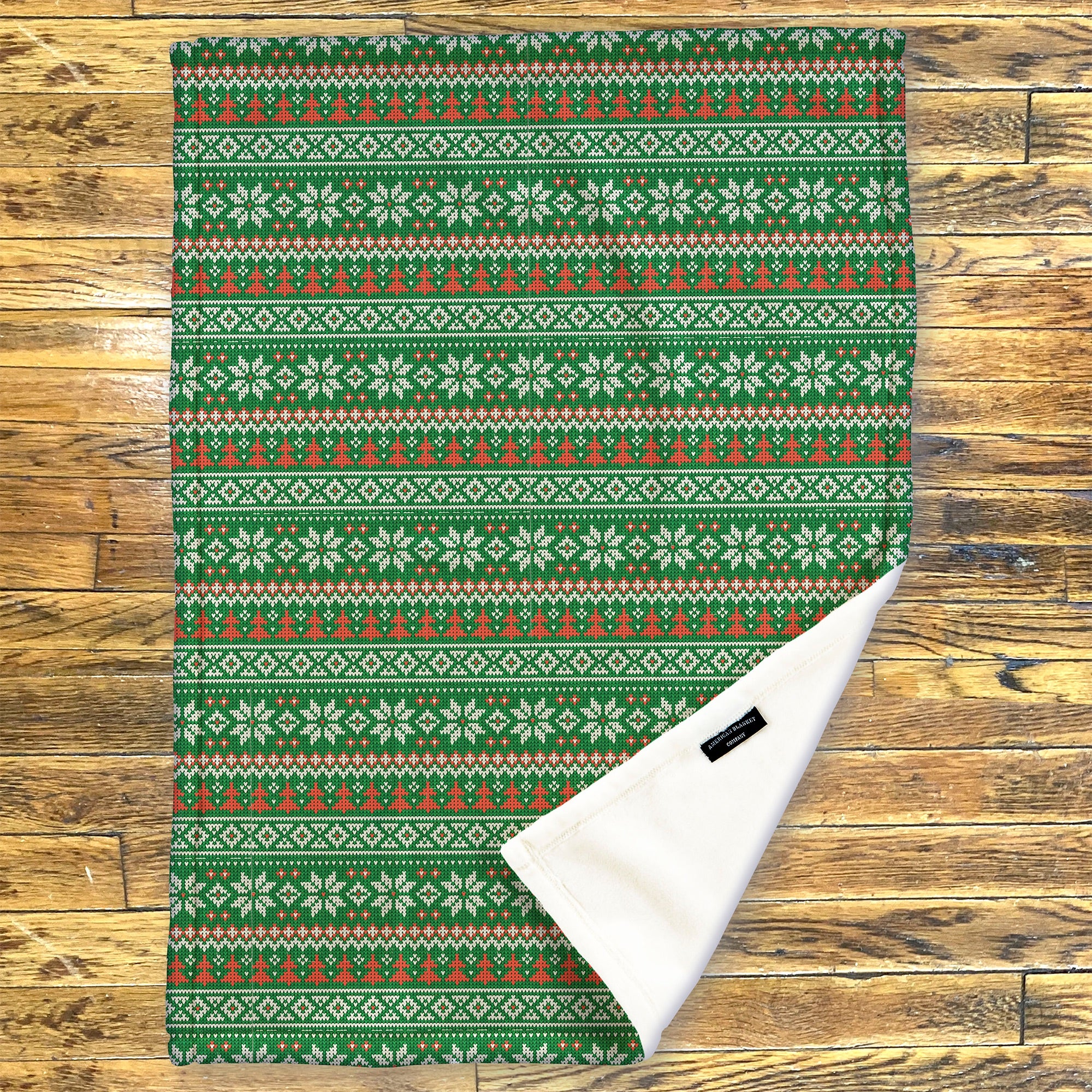 American Blanket Company - Luster Loft Fleece Blanket - Printed Holiday Throw Blanket - Green patterned fleece blanket on a wooden background
