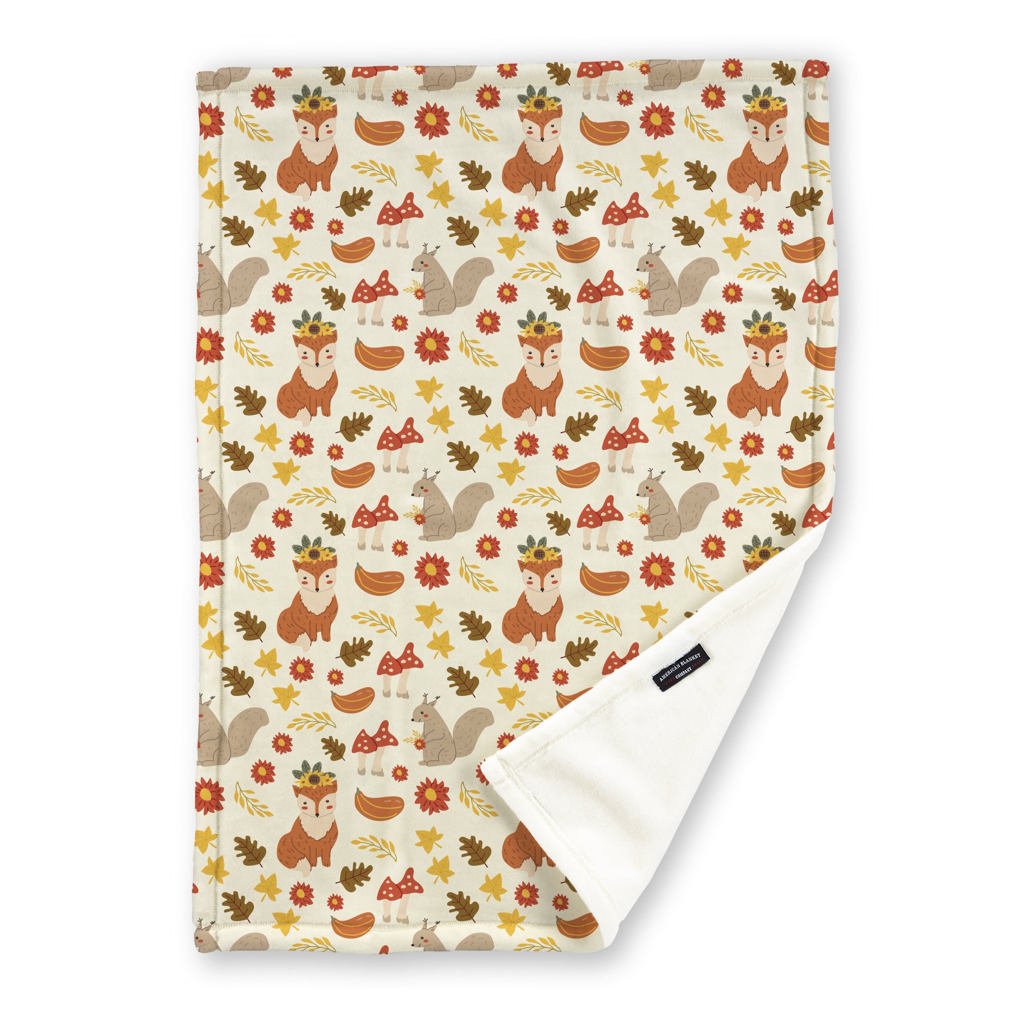 American Blanket Company - Luster Loft Fleece Blanket - Printed Fall Patterned Throw Blanket - A fleece throw blanket with a fall-themed printed pattern on a white background with woodland creatures, plants, and leaves, folded to show the reverse side.