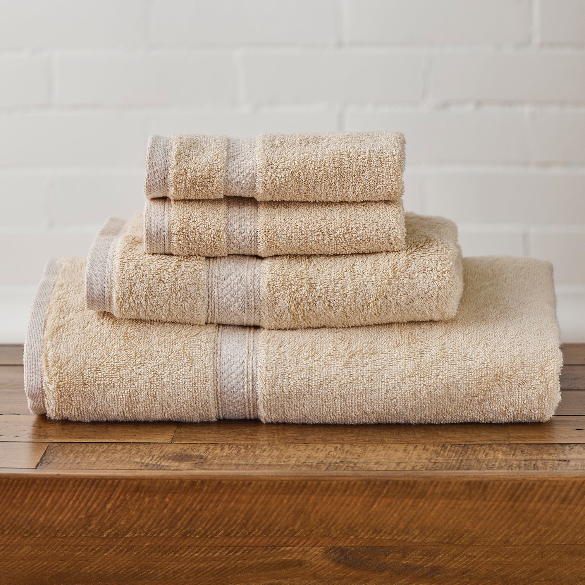 AMERICAN BLANKET COMPANY - 100% COTTON BATH TOWELS  - NEATLY FOLDED GOLDEN 100% COTTON TOWELS ON A WOODEN TRUNK.