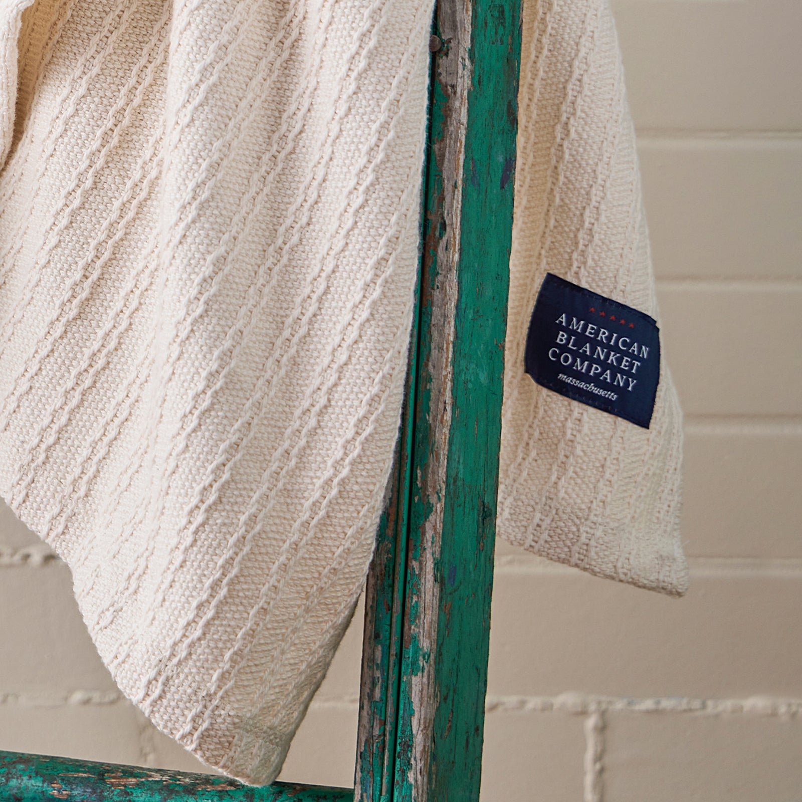 American Blanket Company Oversized 100% Cotton Blanket woven cable weave - A woven 100% cotton blanket draped over a green ladder