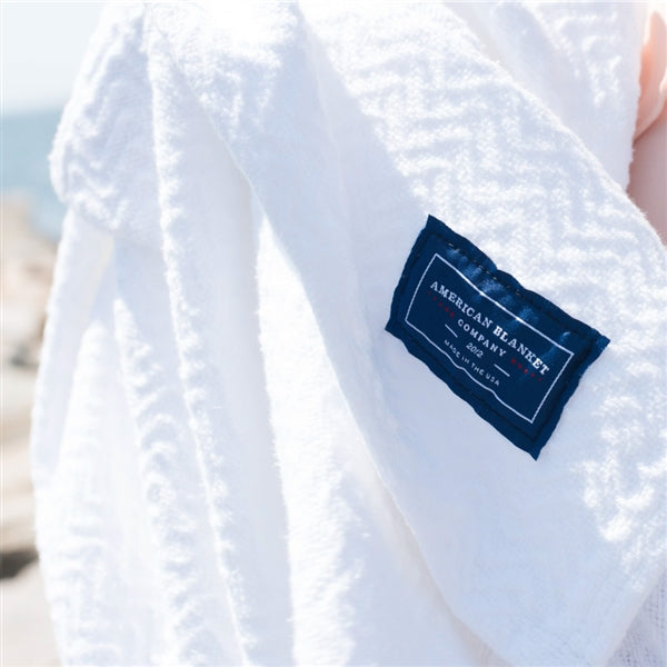 American Blanket Company - 100% Cotton Blanket, Chevron Weave - draped over a woman's arms
