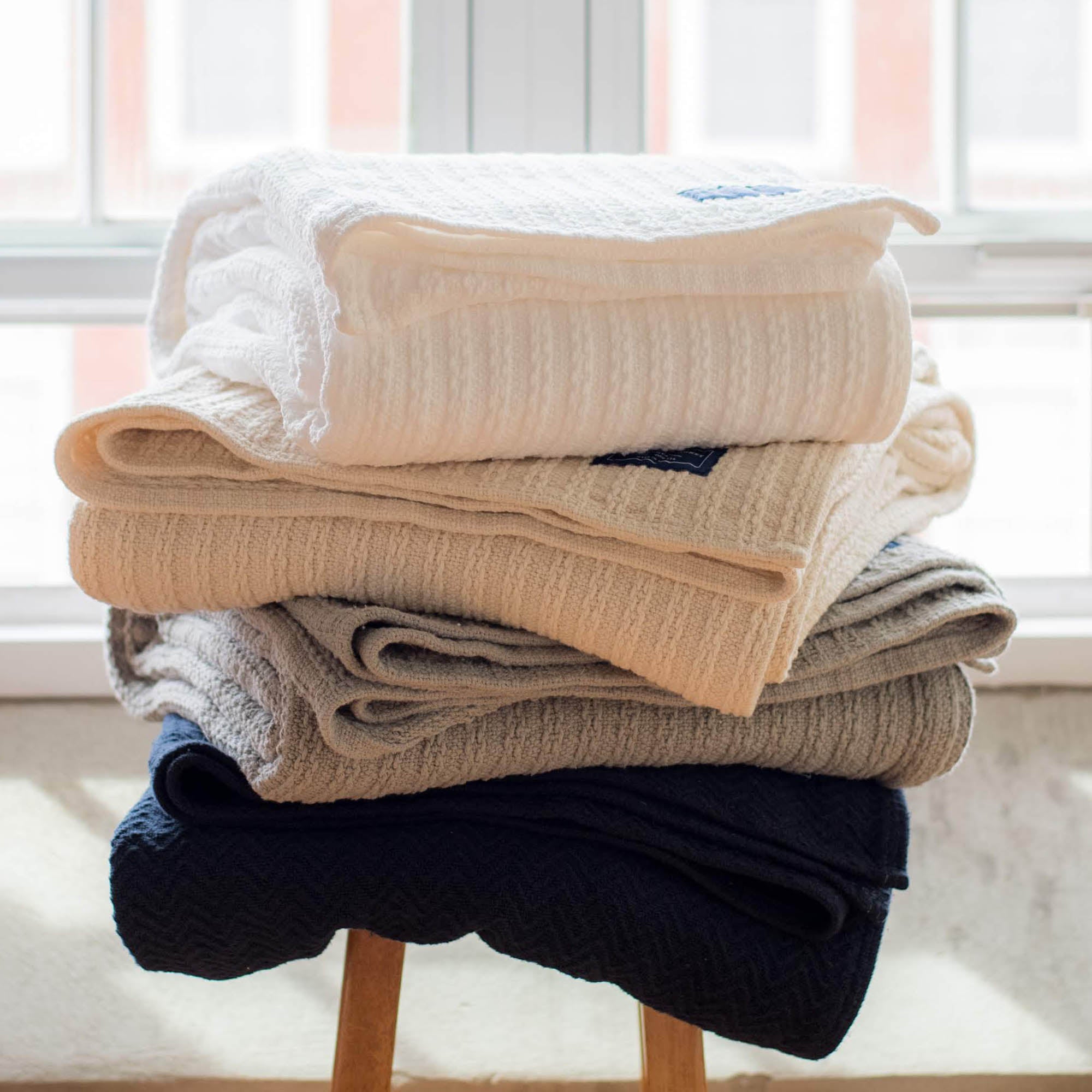 American Blanket Company - Chevron Weave 100% Cotton blankets - Cotton Blankets stacked on arm chair - Chevron Weave 