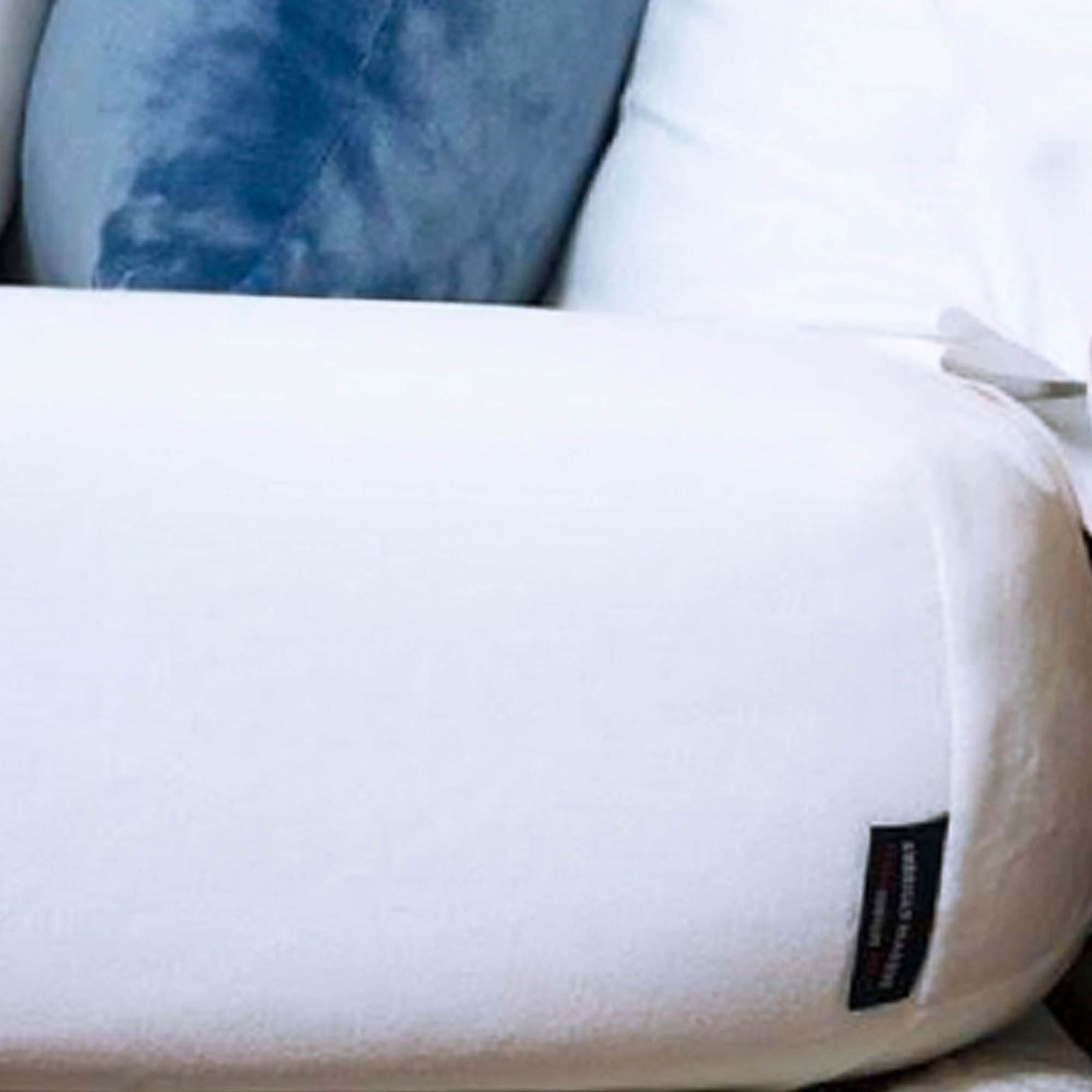 American Blanket Company - Luster Loft Fleece Fitted Sheet - a white fleece fitted sheet detail with a blue throw pillow on top.