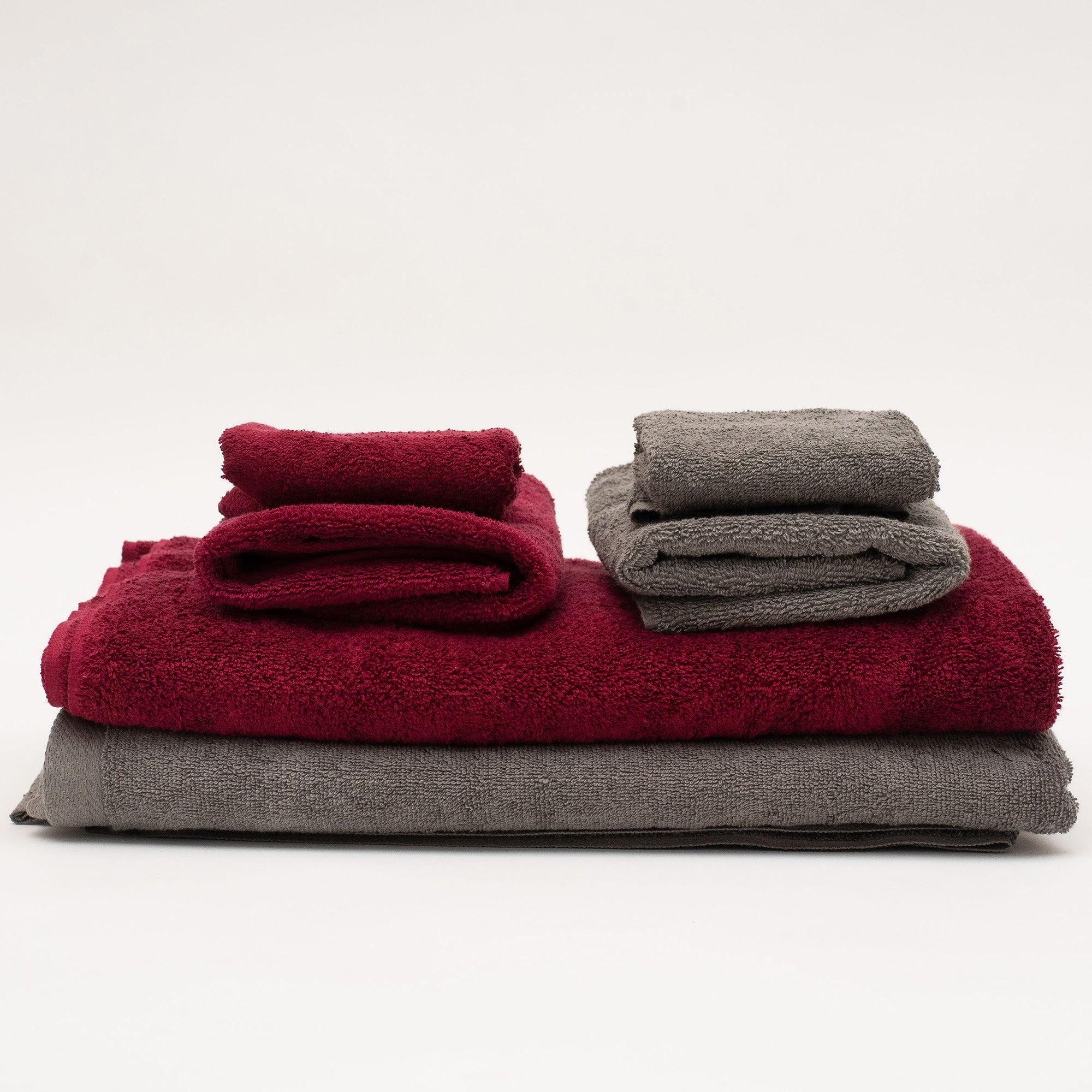 American Blanket Company -  Colorful 100% Cotton Towels - A mixed stack of red and grey cotton towels with corresponding washcloths